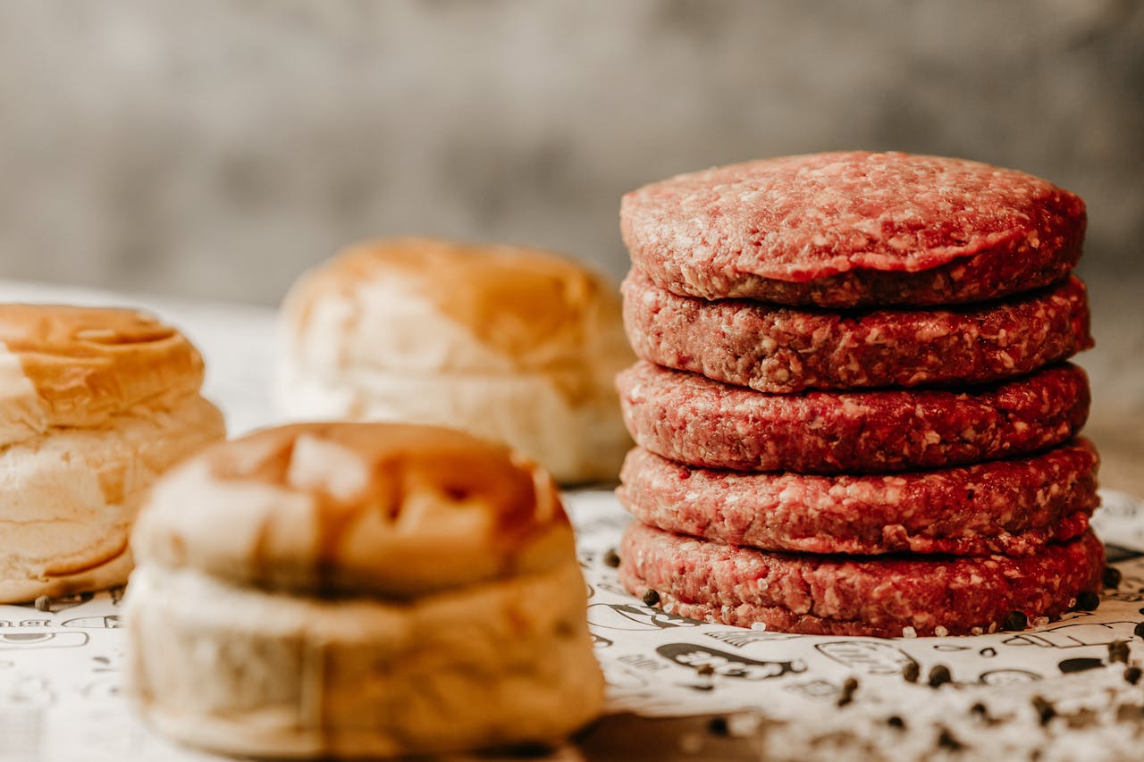 Crafting Captivating Headlines: Your awesome post title goes here A stack of fresh raw beef patties with nearby burger buns, ready for cooking.